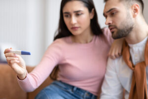 A woman and man read an at-home pregnancy test