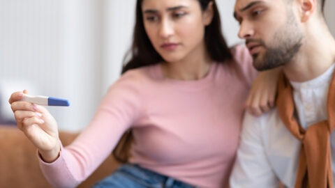 A woman and man read an at-home pregnancy test