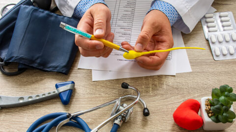 A physician holds a model of a sperm cell