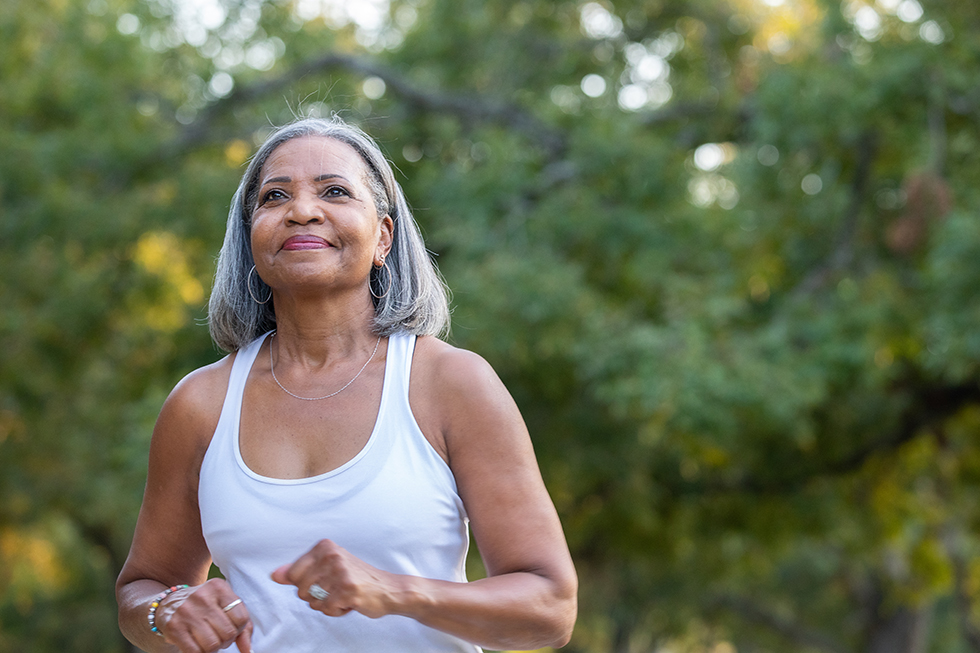 Senior woman jogging in public park