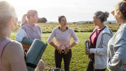 a group of people standing in a circle outdoors doing kegel excercises