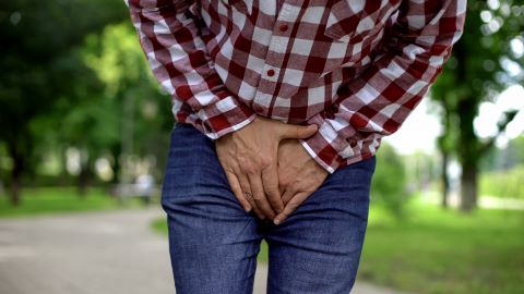 A man holding his groin in discomfort