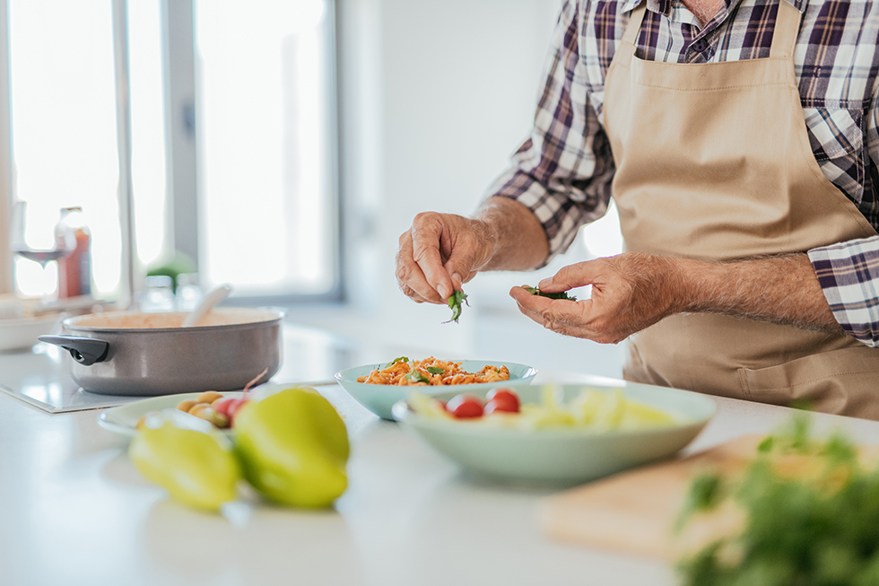 Senior man with gray hair at home cooking at home