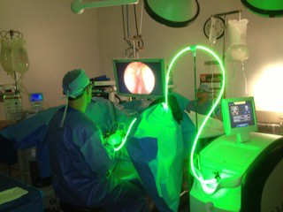 A medical team views an image on a screen while they perform a GreenLight surgery